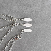 Personalised By Wue bracelet tags engraved with initials, a name and a date