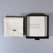 By Wue pouch beside a black gift box with a card reading: long walks in the woods, a loyal, devoted friend, true love comes on paws.