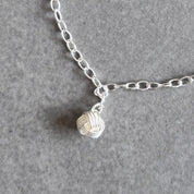 Close up of the bridesmaid knot charm on a By Wue bracelet